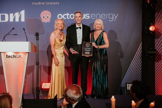 Professor Sir Peter Donnelly, CEO at Genomics, accepts the Economy Award from TechUK president Sheila Flavell and deputy president Nicola Hodson 