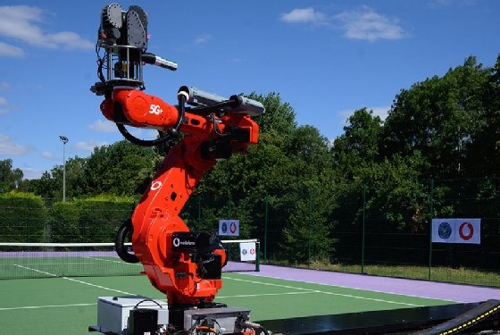 Vodafone’s large, red robotic arm on one side of a tennis court, with the tennis ball dispenser at the top.