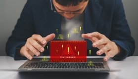 Photo shows someone discovering a software error on a laptop